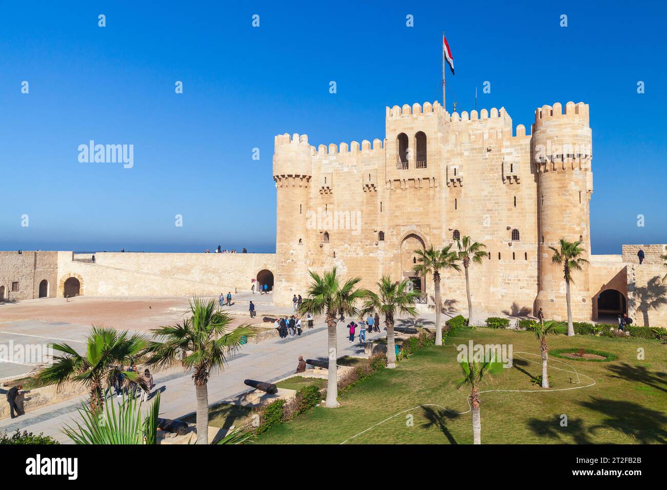 Alexandria, Egypt - December 14, 2018: Visitors walk in front of The Citadel of Qaitbay or the Fort of Qaitbay. It is a 15th-century defensive fortres Stock Photo