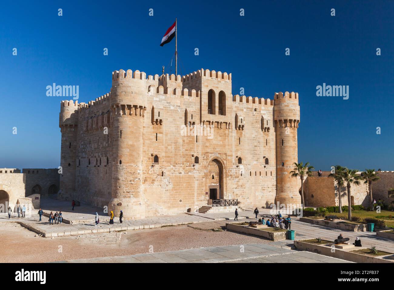 Alexandria, Egypt - December 14, 2018: People walk near The Citadel of Qaitbay or the Fort of Qaitbay. This is a 15th-century defensive fortress locat Stock Photo