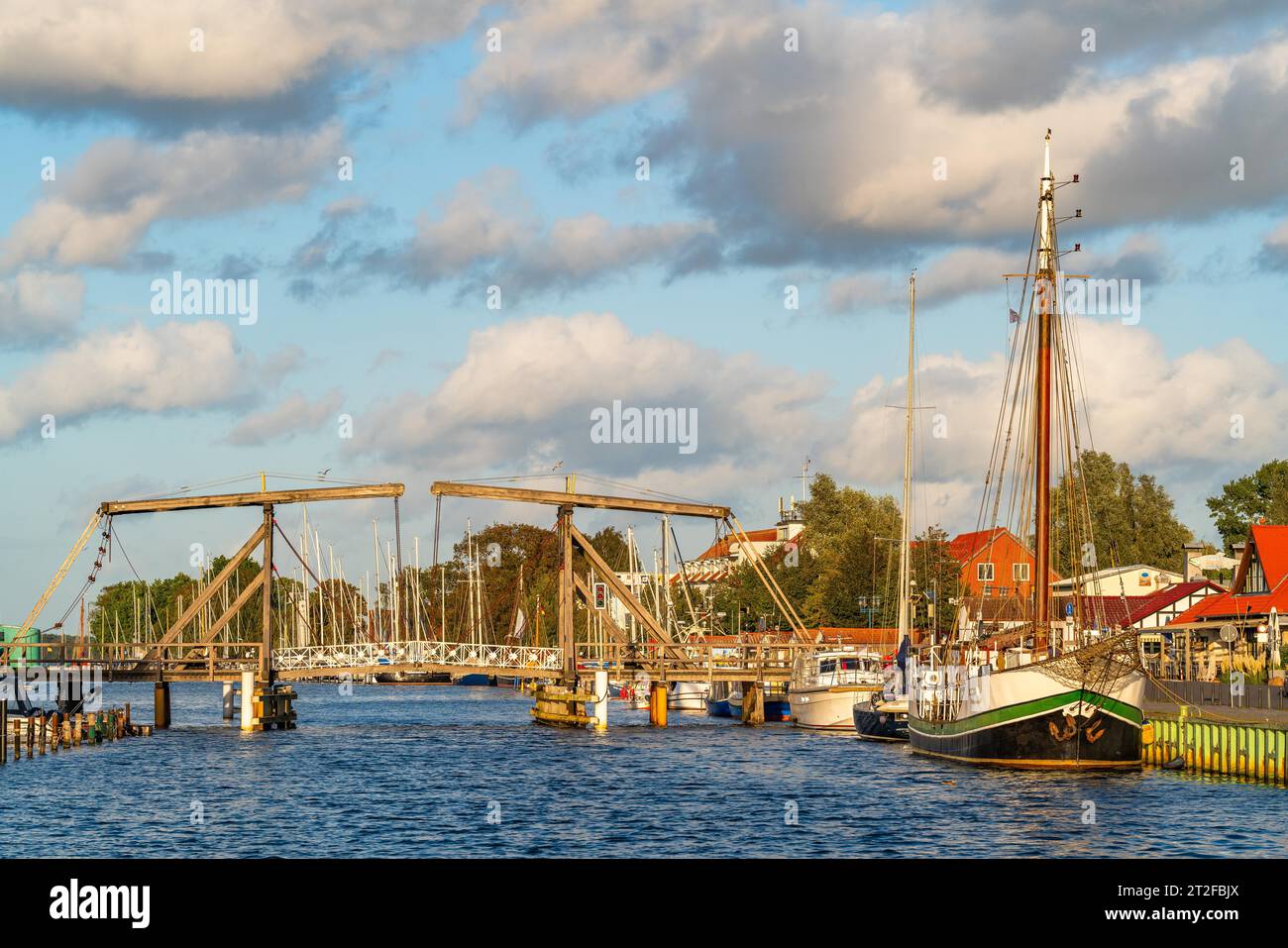 Historic Wieck wooden bascule bridge over the river Ryck and sailing ships in the harbour, Wieck fishing village, Greifswald, Mecklenburg-Western Stock Photo