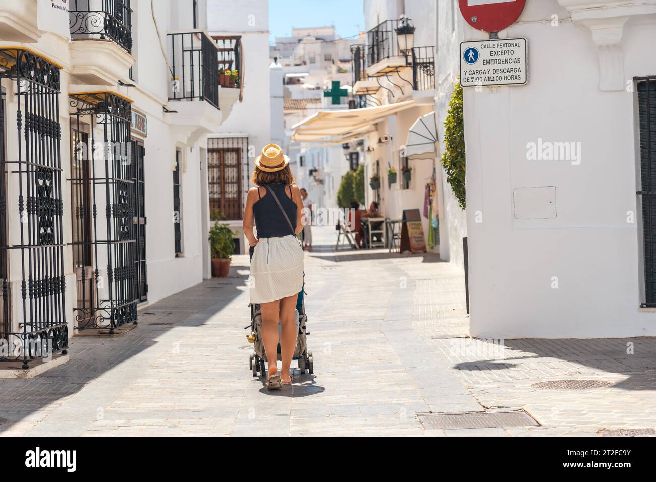A young mother with her baby walking through Vejer de la Frontera, Cadiz. Holidays in Andalusia Stock Photo