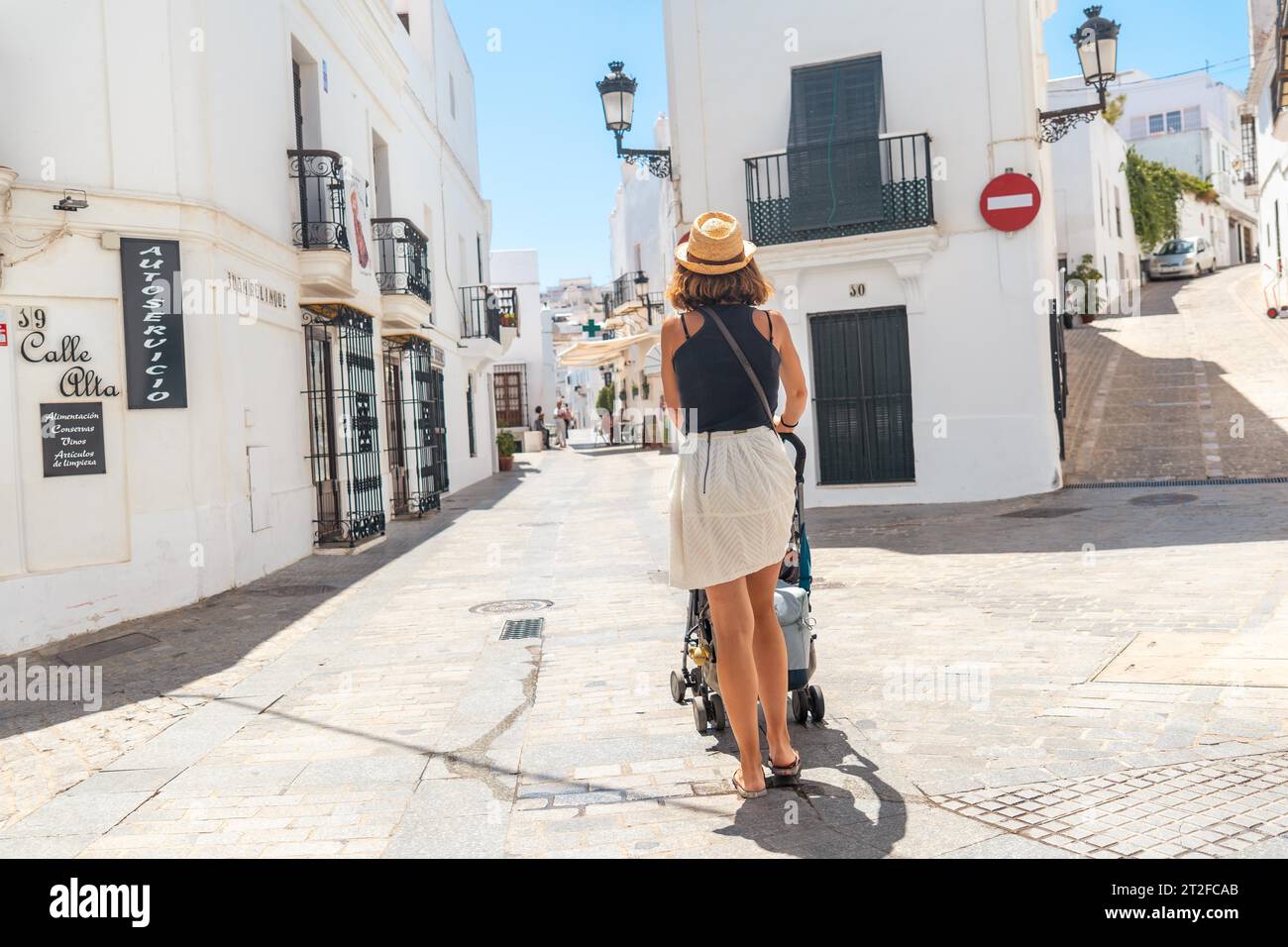 A young mother with her baby walking through Vejer de la Frontera, Cadiz. summer holidays, mediterranean Stock Photo
