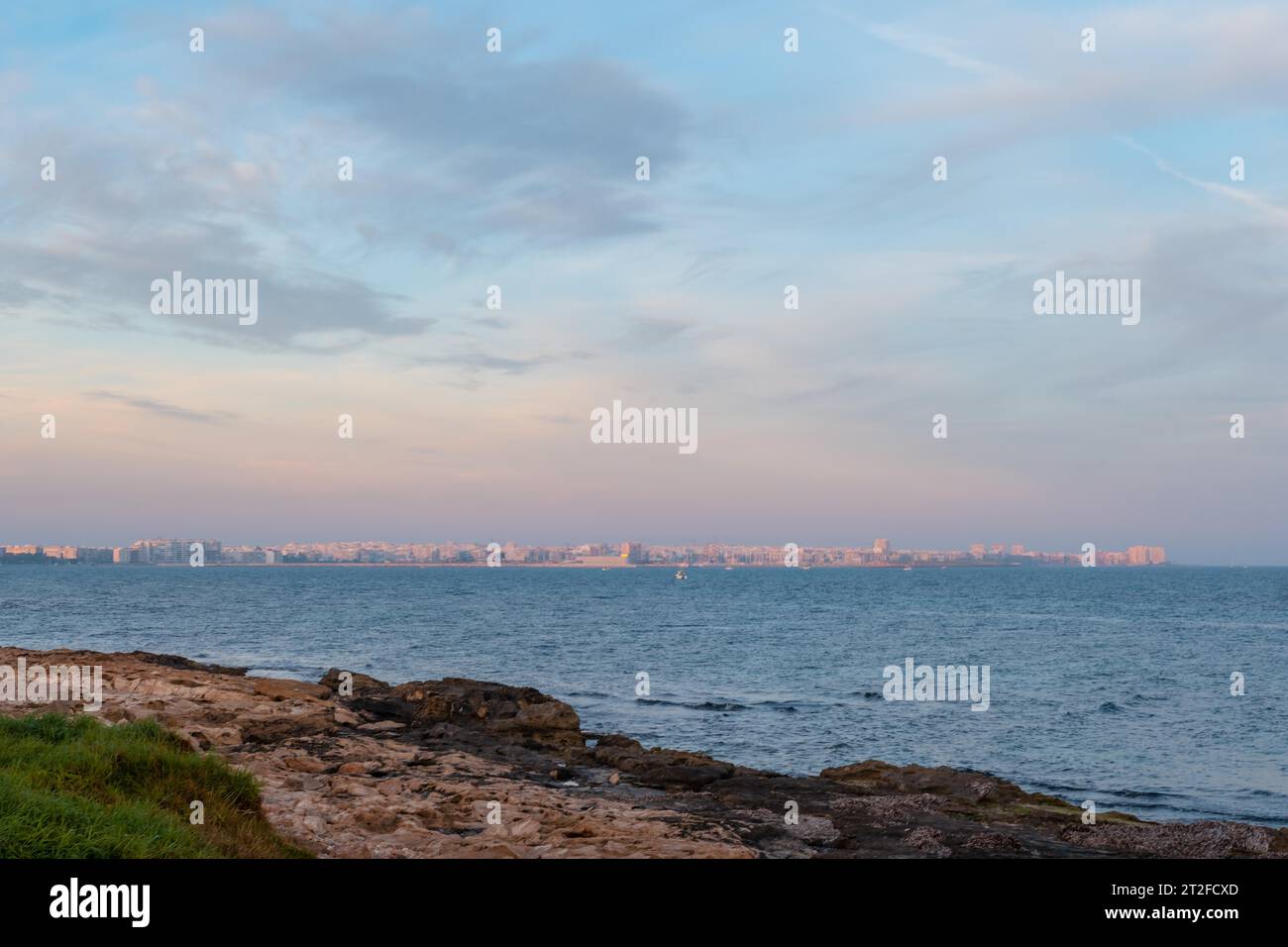 View of the coastal town of Torrevieja from Cala Ferris at sunset, Alicante, Valencian Community. Spain, Mediterranean Sea Stock Photo