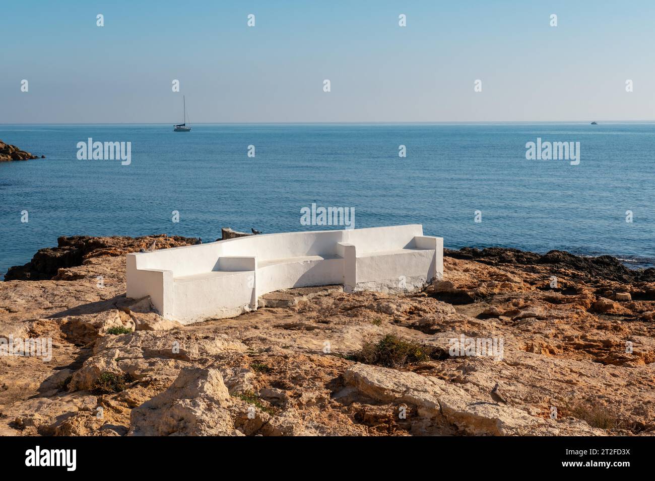 A white seat by the sea in the coastal town of Torrevieja next to Playa del Cura, Alicante, Valencian Community. Spain, Mediterranean Sea on the Stock Photo