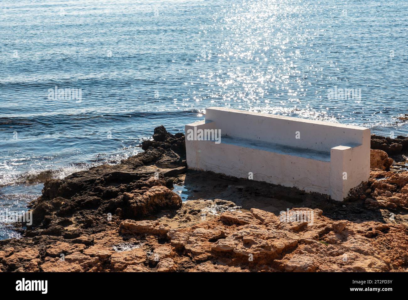 A white seat by the sea in the coastal town of Torrevieja next to Playa del Cura, Alicante, Valencian Community. Spain, Mediterranean Sea on the Stock Photo