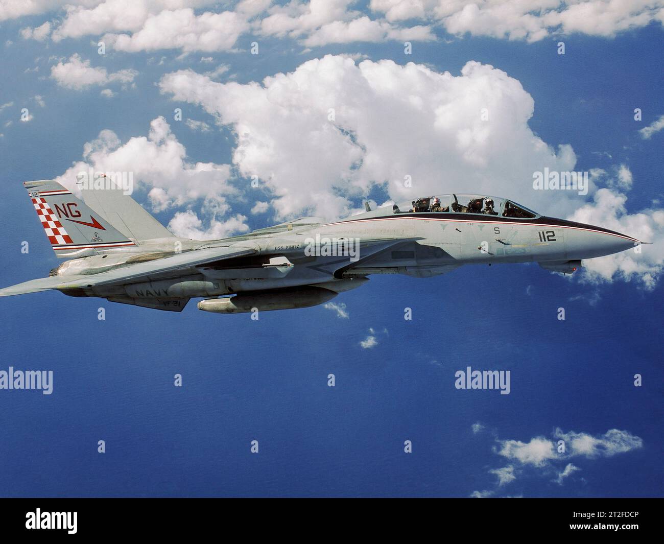 Colorful F-14 Tomcat flying among puffy clouds. Stock Photo