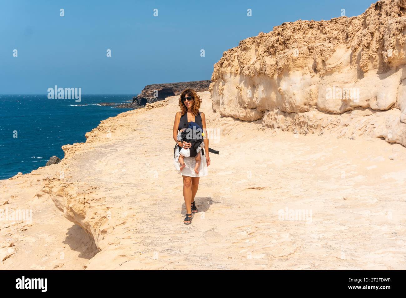 A young mother with her son walking on the path in the Cuevas de Ajuy, Pajara, west coast of the island of Fuerteventura, Canary Islands. Spain Stock Photo