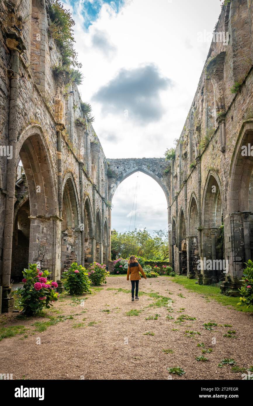A young woman visiting the ruins of the Abbaye de Beauport church in the village of Paimpol, Cotes-d'Armor department, French Brittany. France Stock Photo