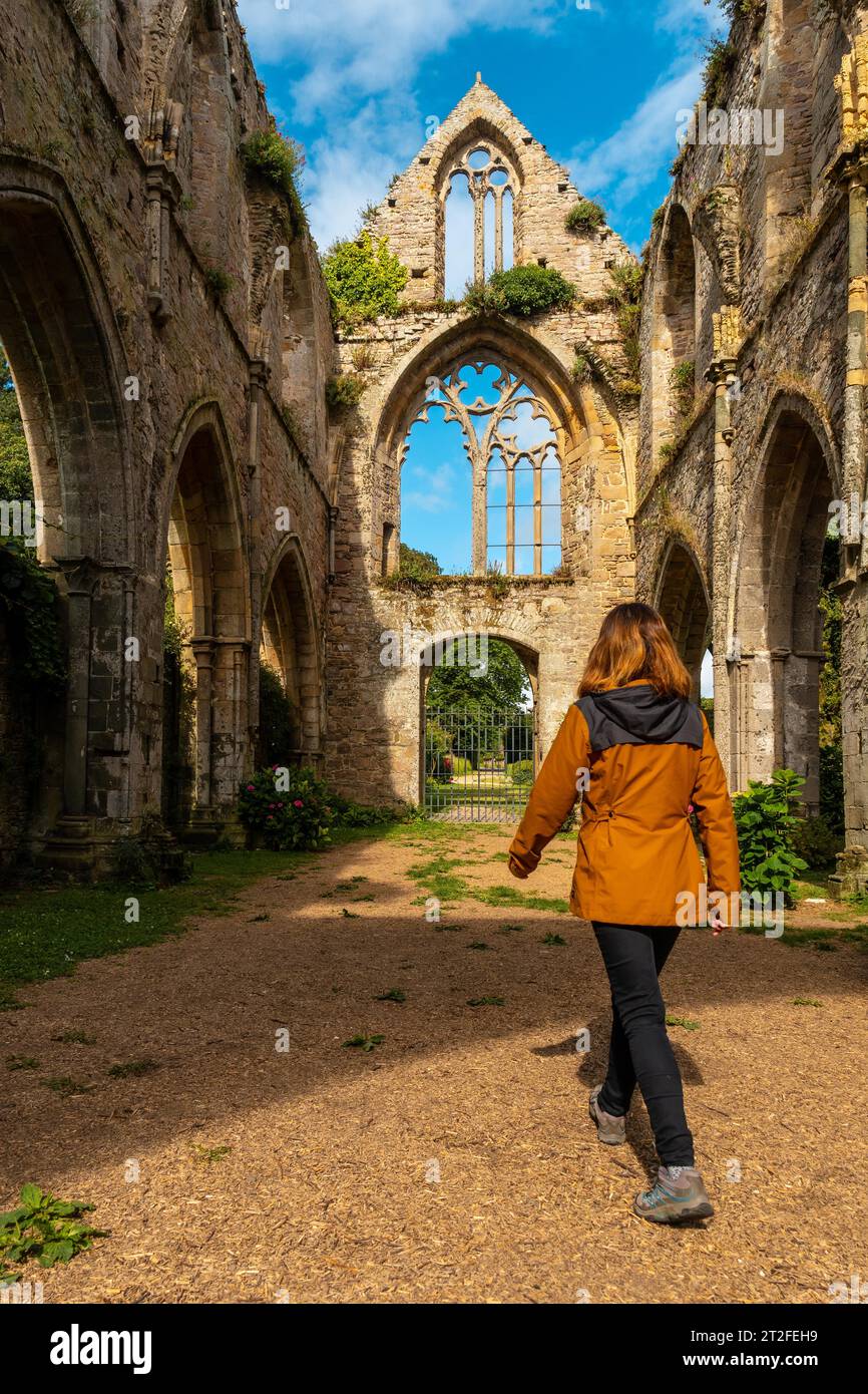 A young woman visiting the ruins of the Abbaye de Beauport church in the village of Paimpol, Cotes-d'Armor department, French Brittany. France Stock Photo