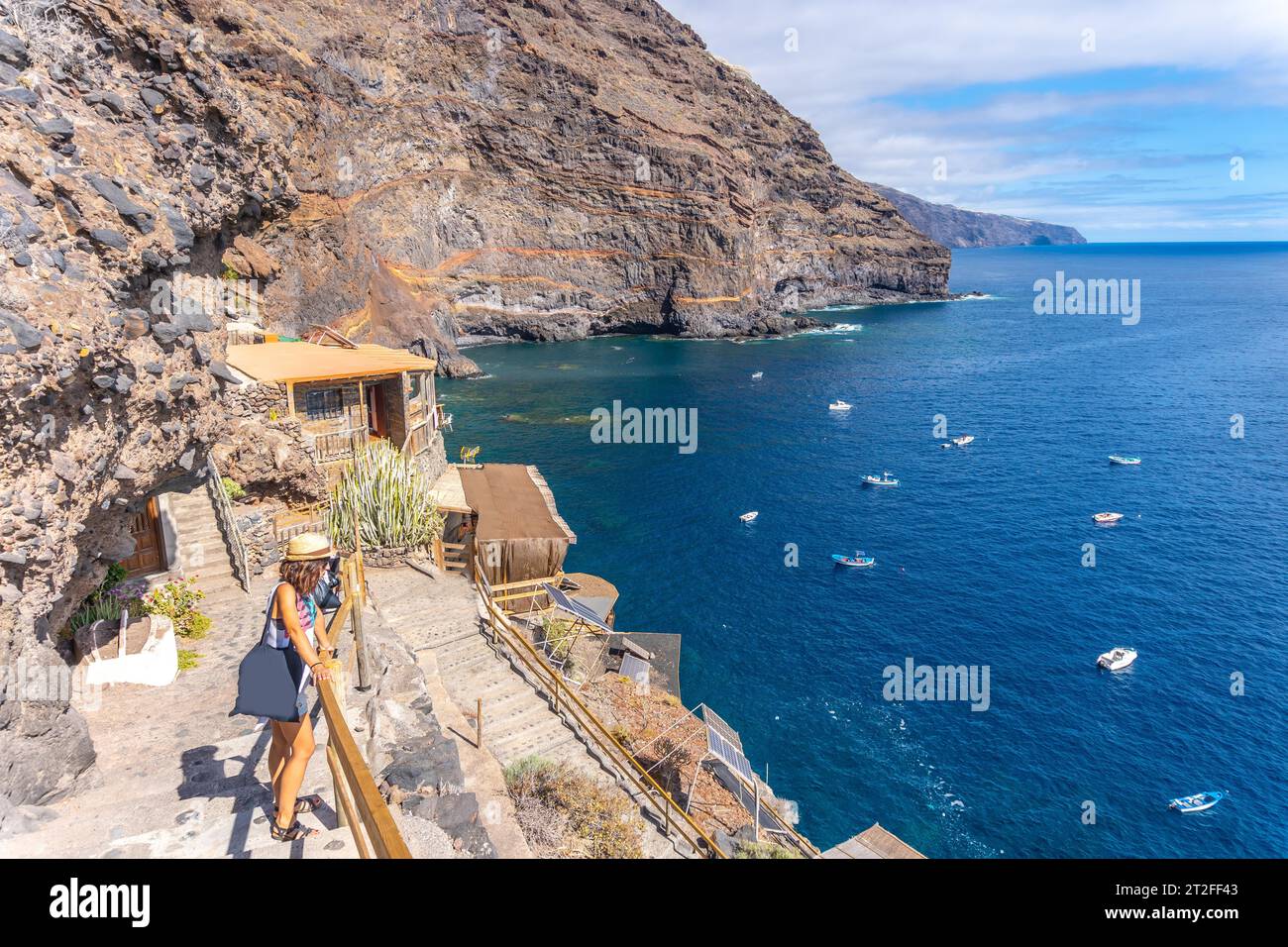 A young tourist in summer from the viewpoint looking and enjoying the cove of Puerto de Puntagorda, island of La Palma, Canary Islands. Spain Stock Photo