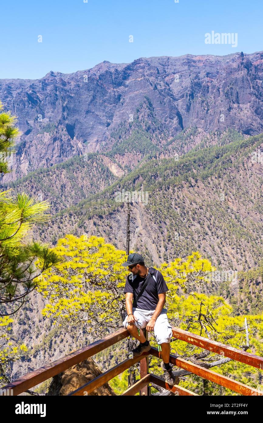 A young tourist at the Mirador Lomo de las Chozas de La Cumbrecita on the island of La Palma next to the Caldera de Taburiente, Canary Islands. Spain Stock Photo