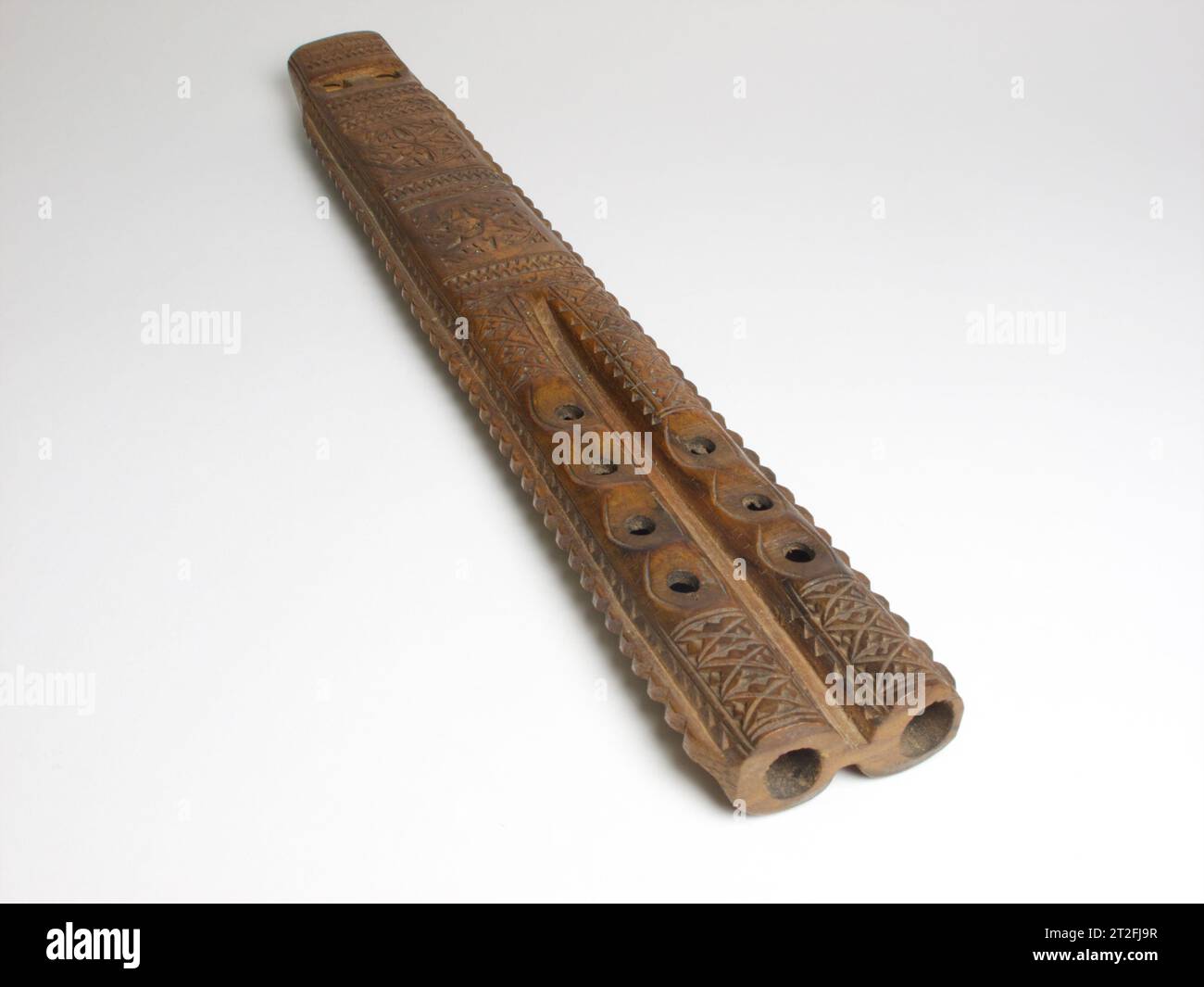 Vintage Hungarian wooden double flute with hand carved decoration. The musical instrument measures 33cm long. cap Stock Photo