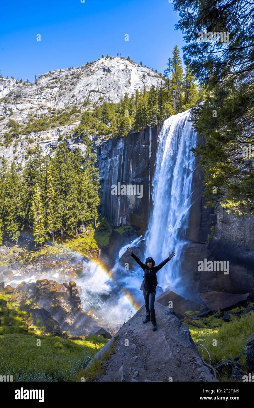 A woman in Long Vernal Falls waterfall in Yosemite National Park ...