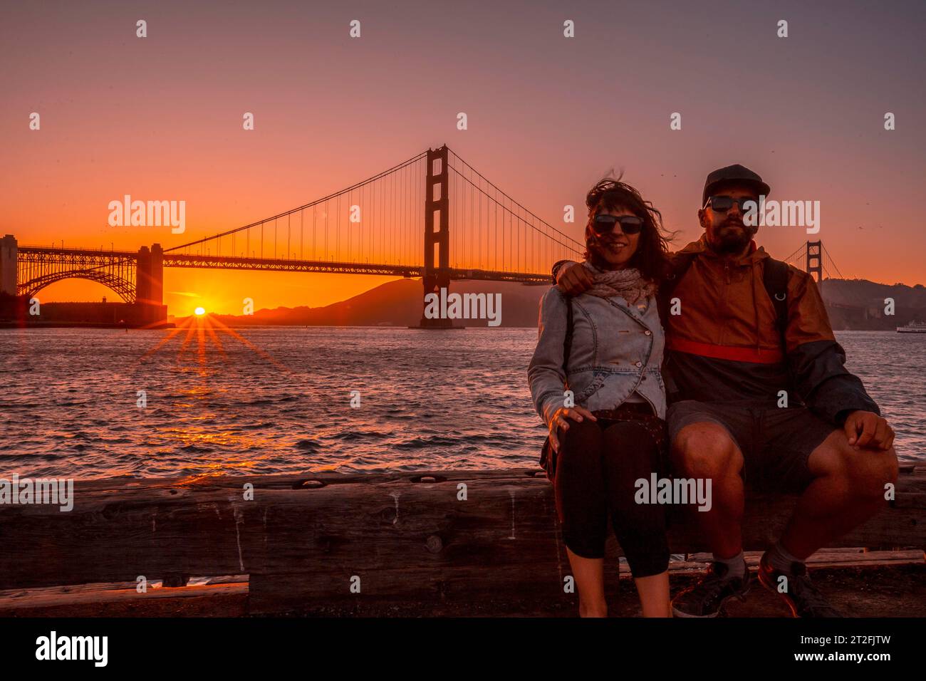 A couple in red sunset at the Golden Gate of San Francisco. United States Stock Photo