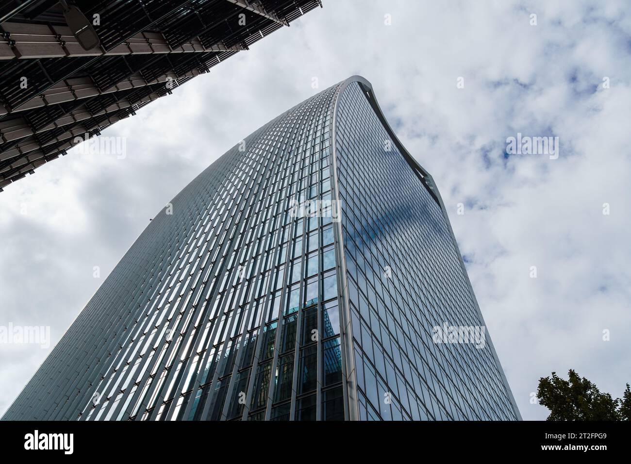 London, UK - August 25, 2023: Low angle view of modern office buildings in the City of London and reflections on curtain wall facade. View against blu Stock Photo