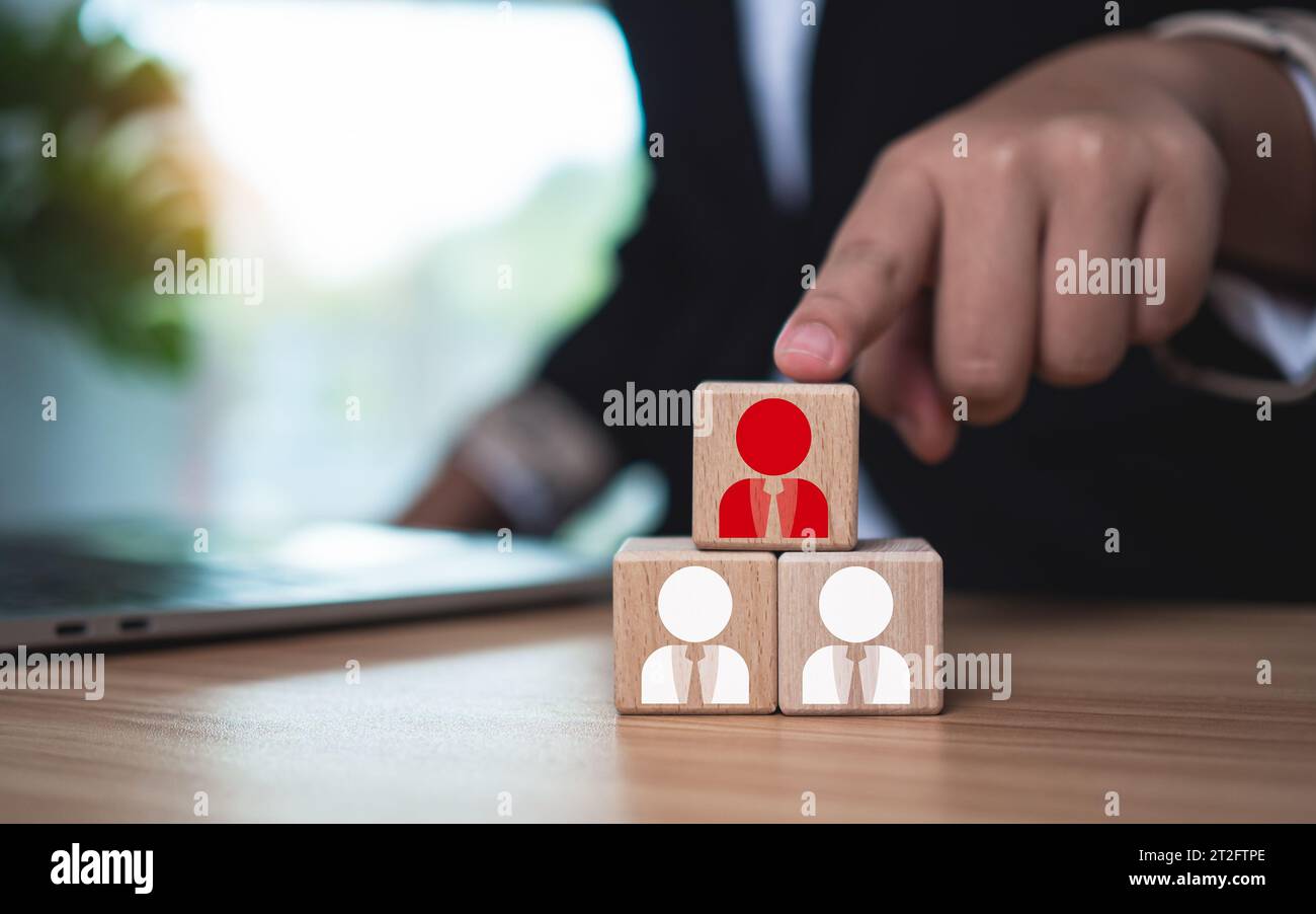 Wooden blocks with printed manager icons selected by businessmen to express human resource management and leadership concepts. Stock Photo