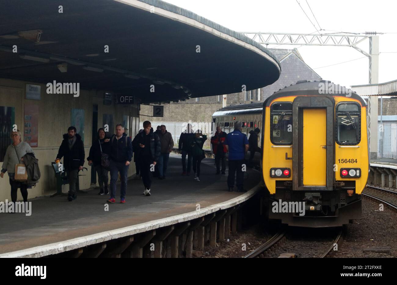 Longest unsupported curved cantilever roof at Carnforth station, passengers on platform leaving Northern train diesel multiple unit 18th October 2023. Stock Photo