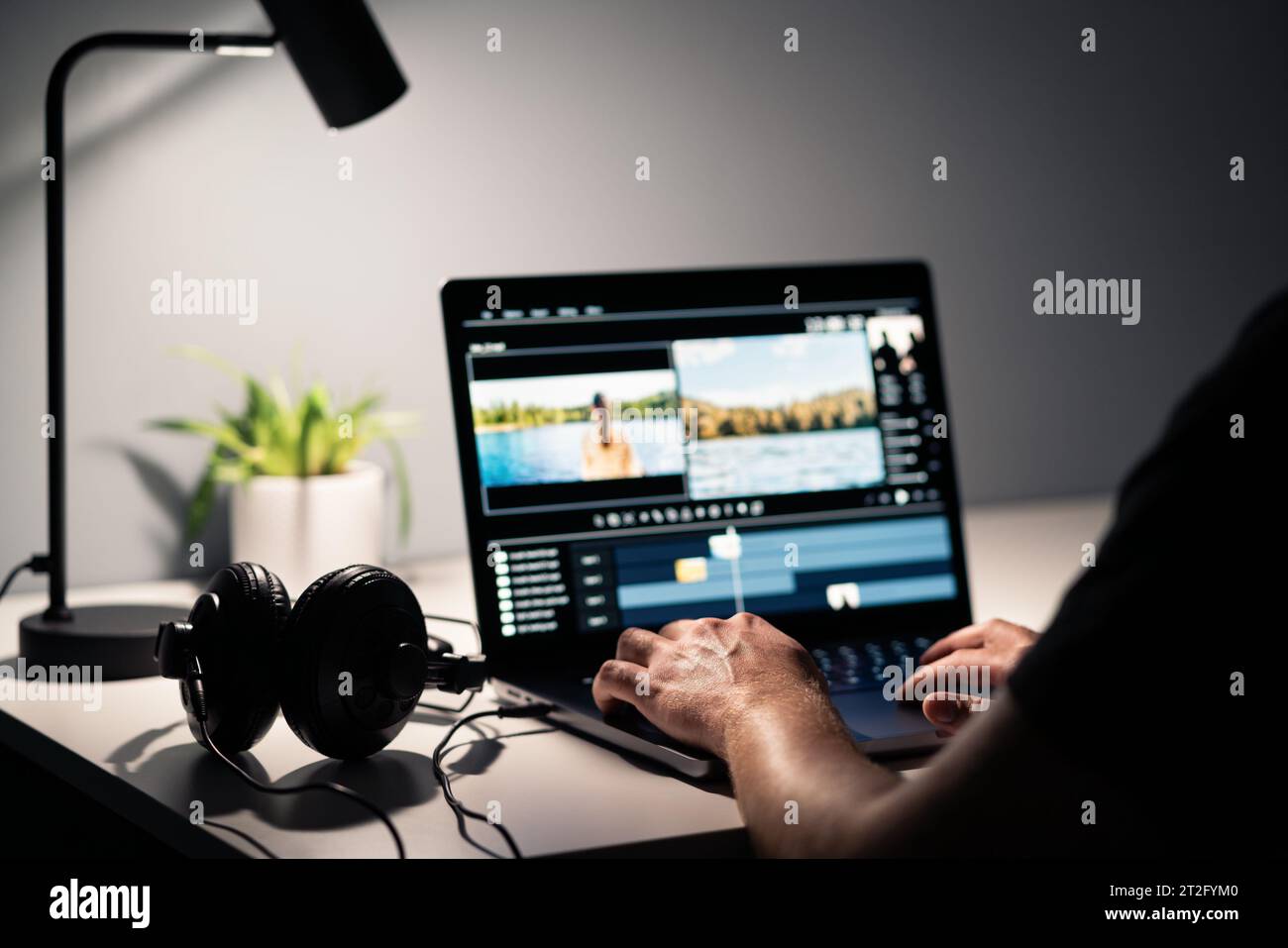 Video edit with film editor. Making movie with computer. Headphones and laptop. Sound, audio and music designer. Man working with content production. Stock Photo