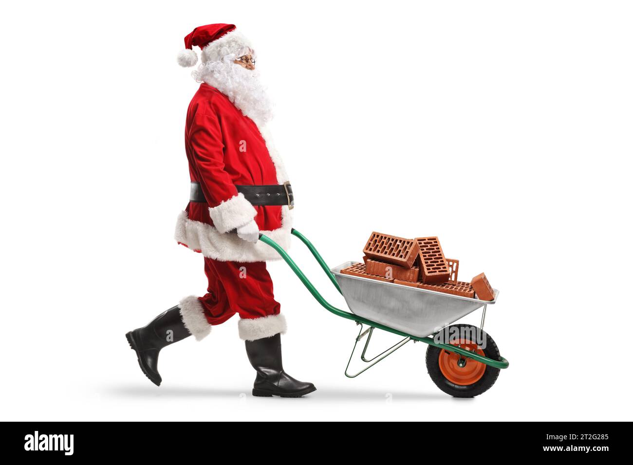 Santa claus walking and pushing bricks in a wheelbarrow isolated on white background Stock Photo