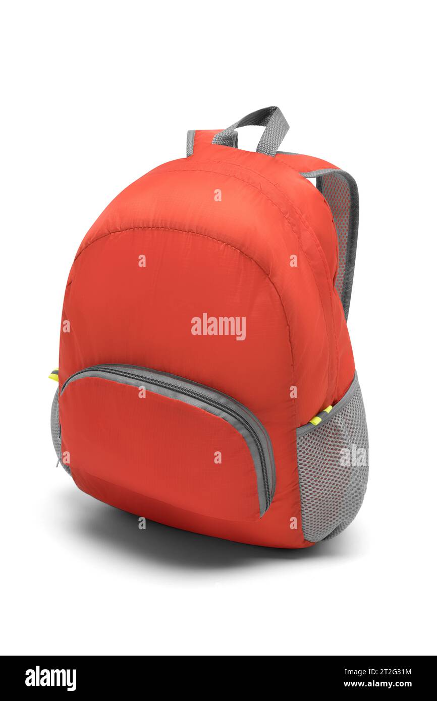 blank red backpack with zipper and shoulder straps isolated on white background. travel day pack rucksack. folding nylon school backpack. side view. Stock Photo