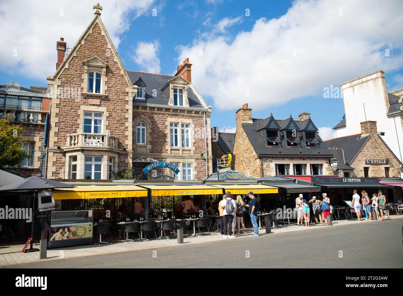 Tourists outside a café with the typical architecture in the center of Paimpol, a charming town in Cotes d'Armor, Brittany, France. Stock Photo