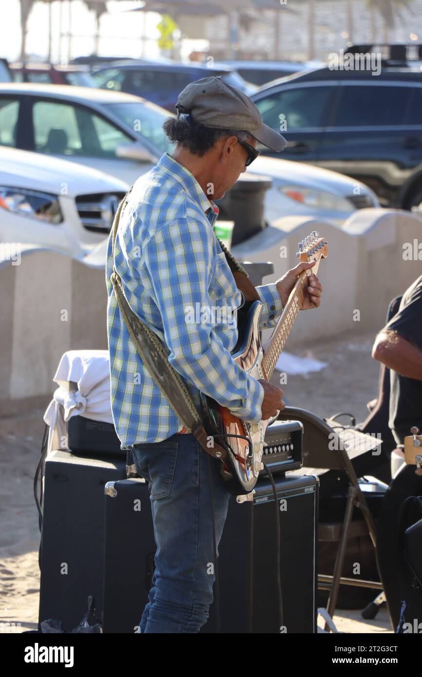A photo of an old non recognizable man playing a guitar on the