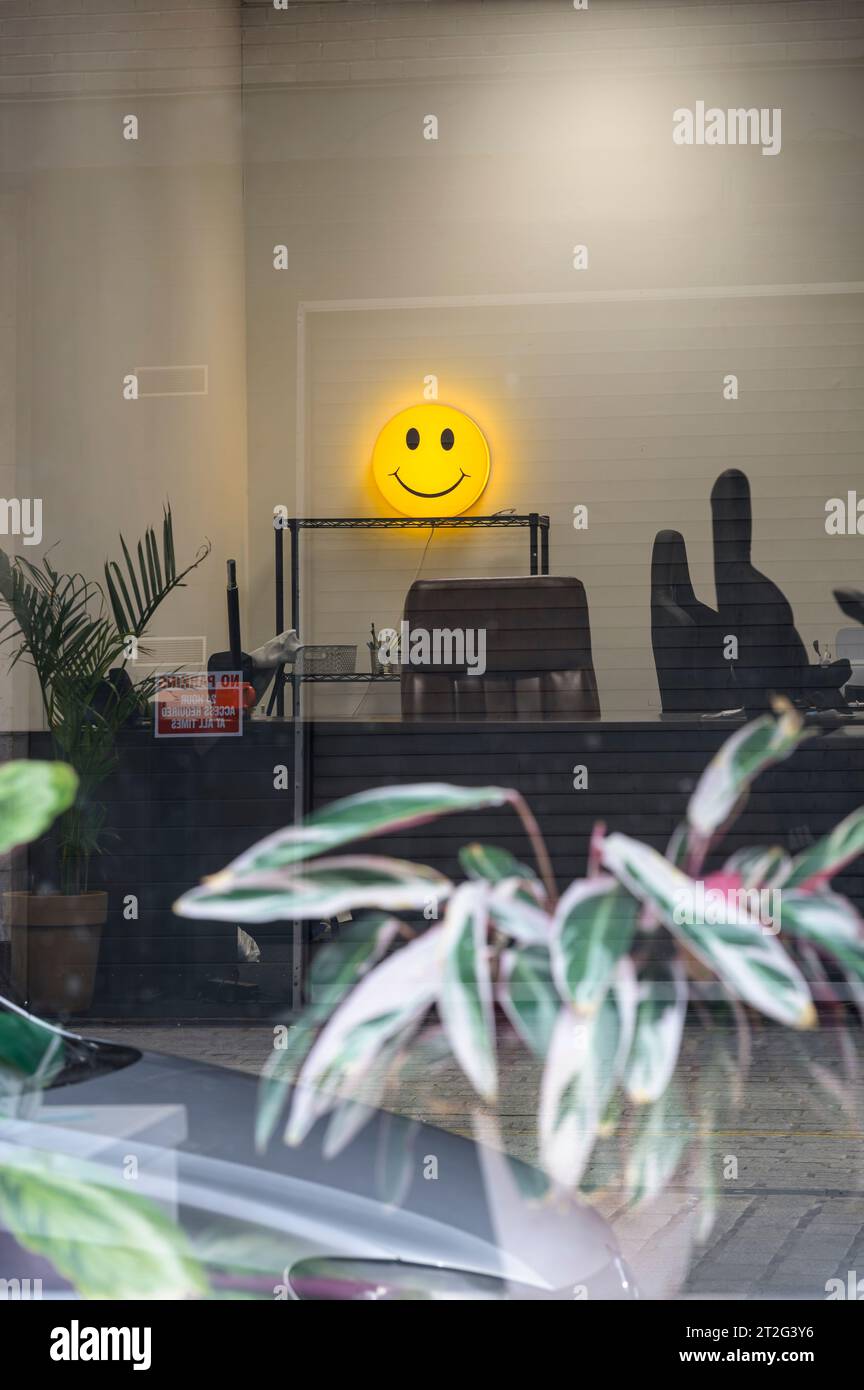 Looking in through an empty office window with a yellow smiley face Stock Photo