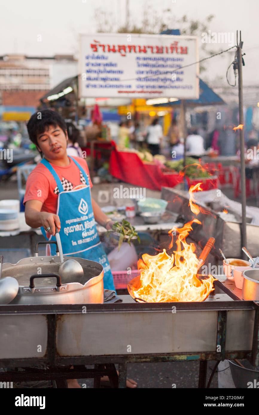Flames from a wok, street food at a night market in Ayutthaya, Thailand Stock Photo