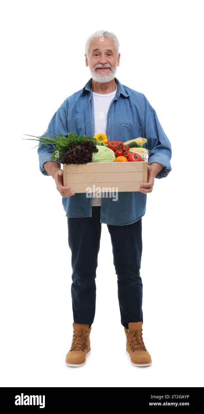 Harvesting season. Happy farmer holding wooden crate with vegetables on ...
