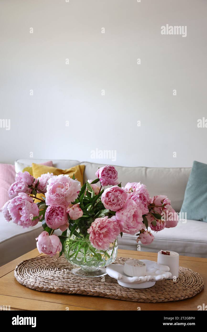 Beautiful pink peonies in vase on table at home, space for text ...