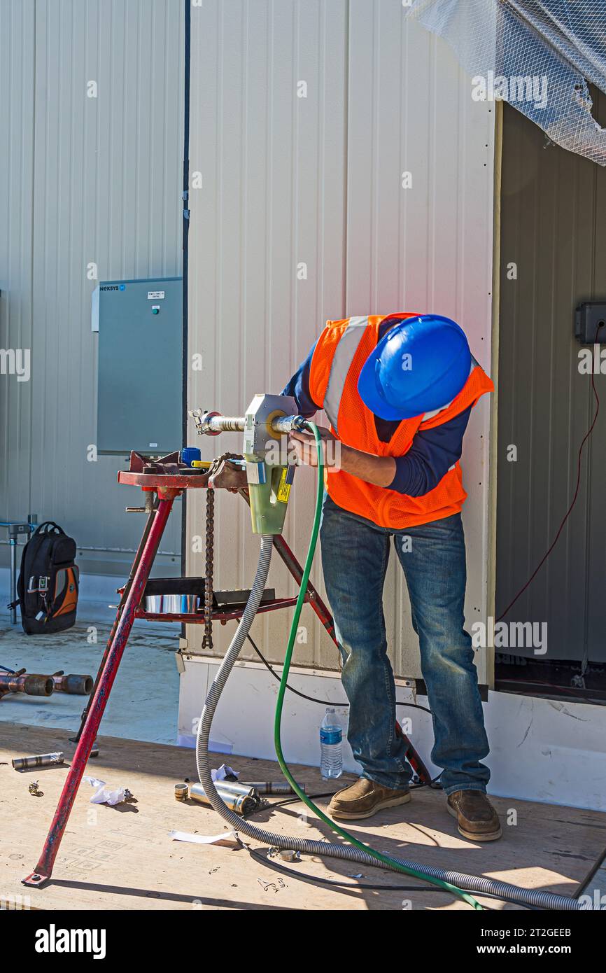A construction worker setting up a stainless steel pipe welding