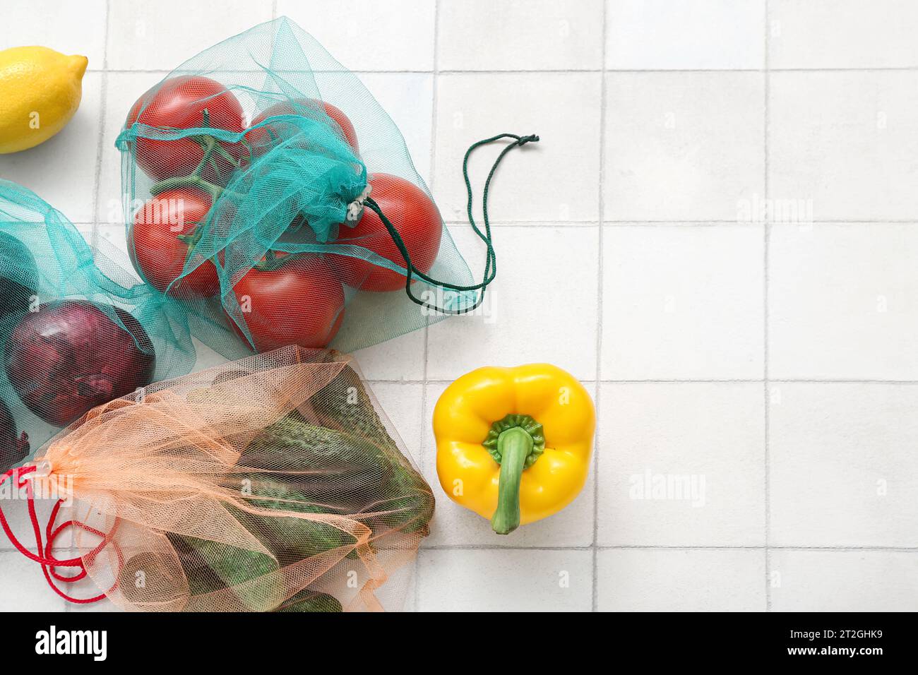 Eco bags with different fresh vegetables on light tile background Stock ...