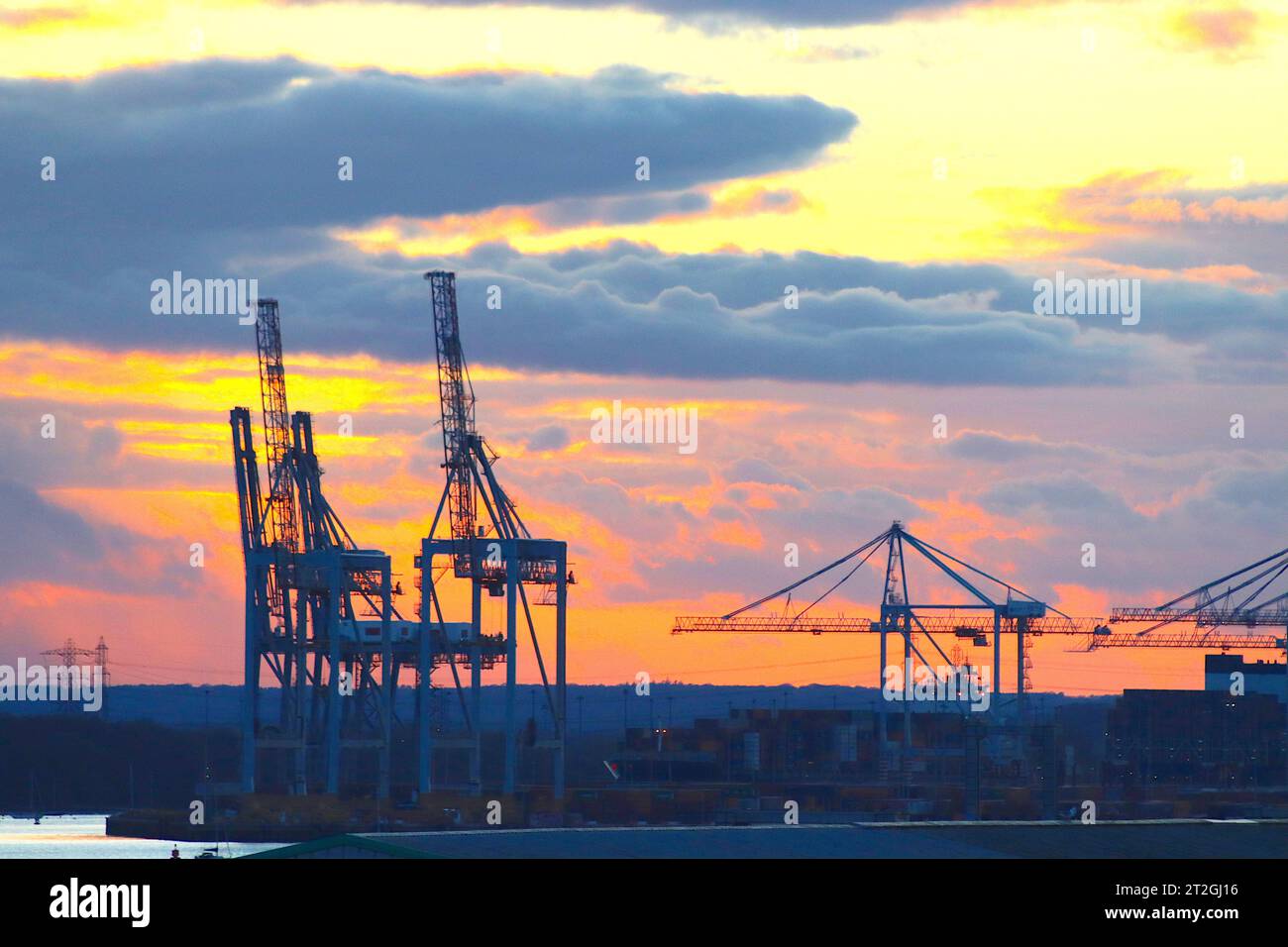 Sunset after wintery showers over Southampton’s container terminal in the River Test, April 2022. Stock Photo