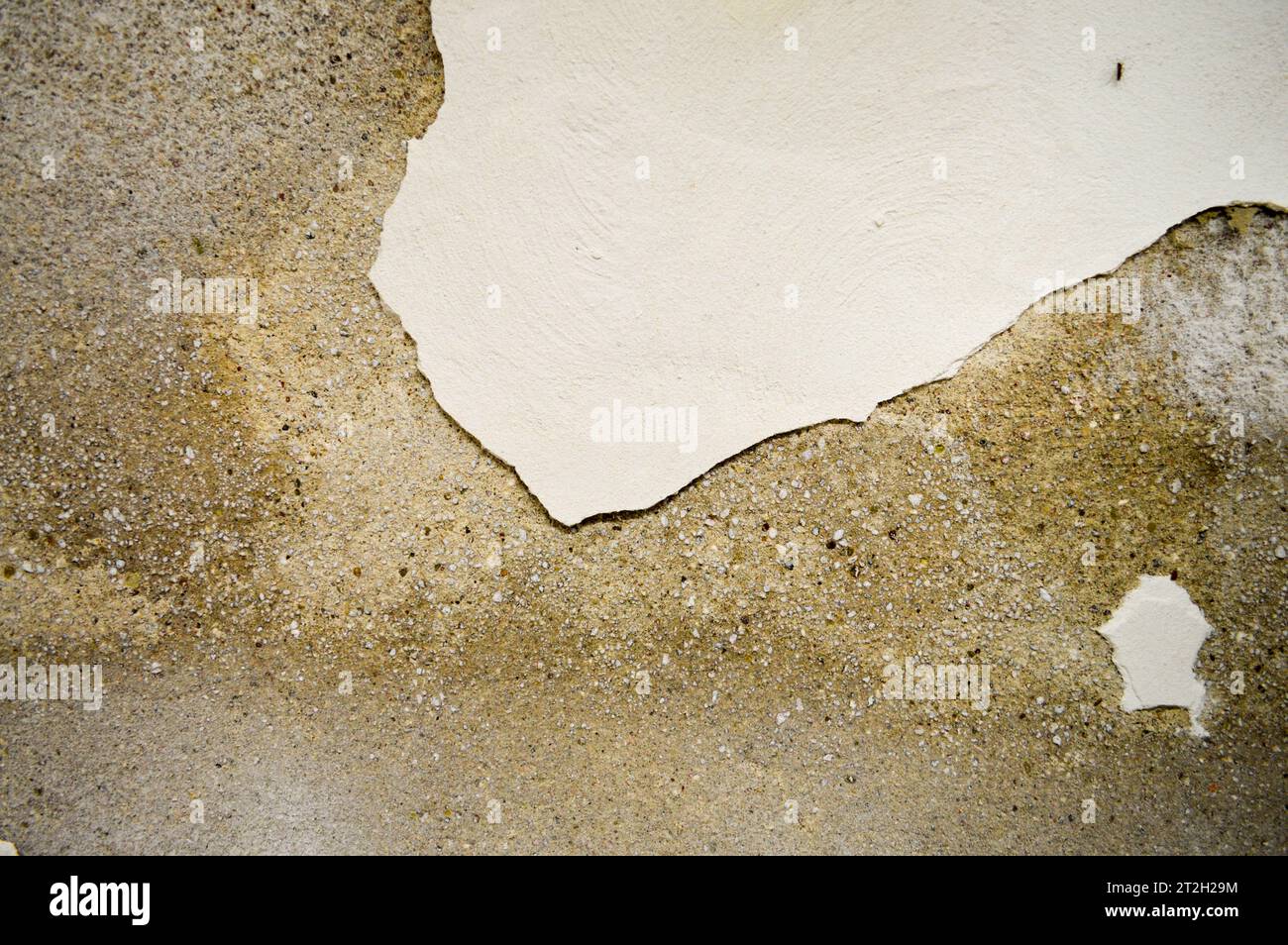 The texture of the stone concrete old shabby wall with cracks and chips with whitewashing and exfoliated plaster, putty. The background. Stock Photo