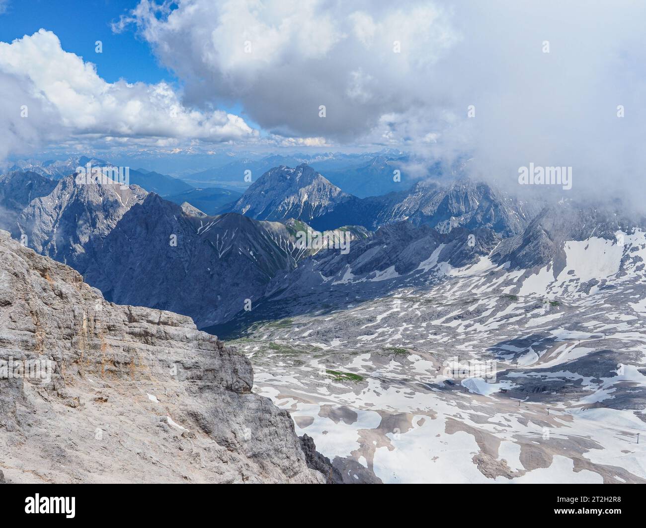 Beautiful landscape with Alpine mountains and cloudy sky. Snowy peaks in Bavaria. View from the observation deck at the top of Zugspitze. Germany. Stock Photo