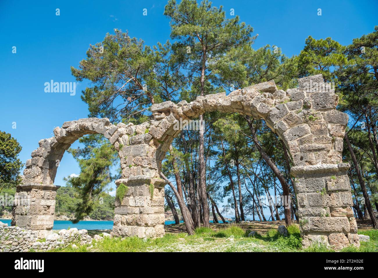 Ruined aqueduct at Phaselis ancient site in Antalya, Turkey. The aqueducts supplied fresh water to public baths and for drinking water. Bridges, built Stock Photo