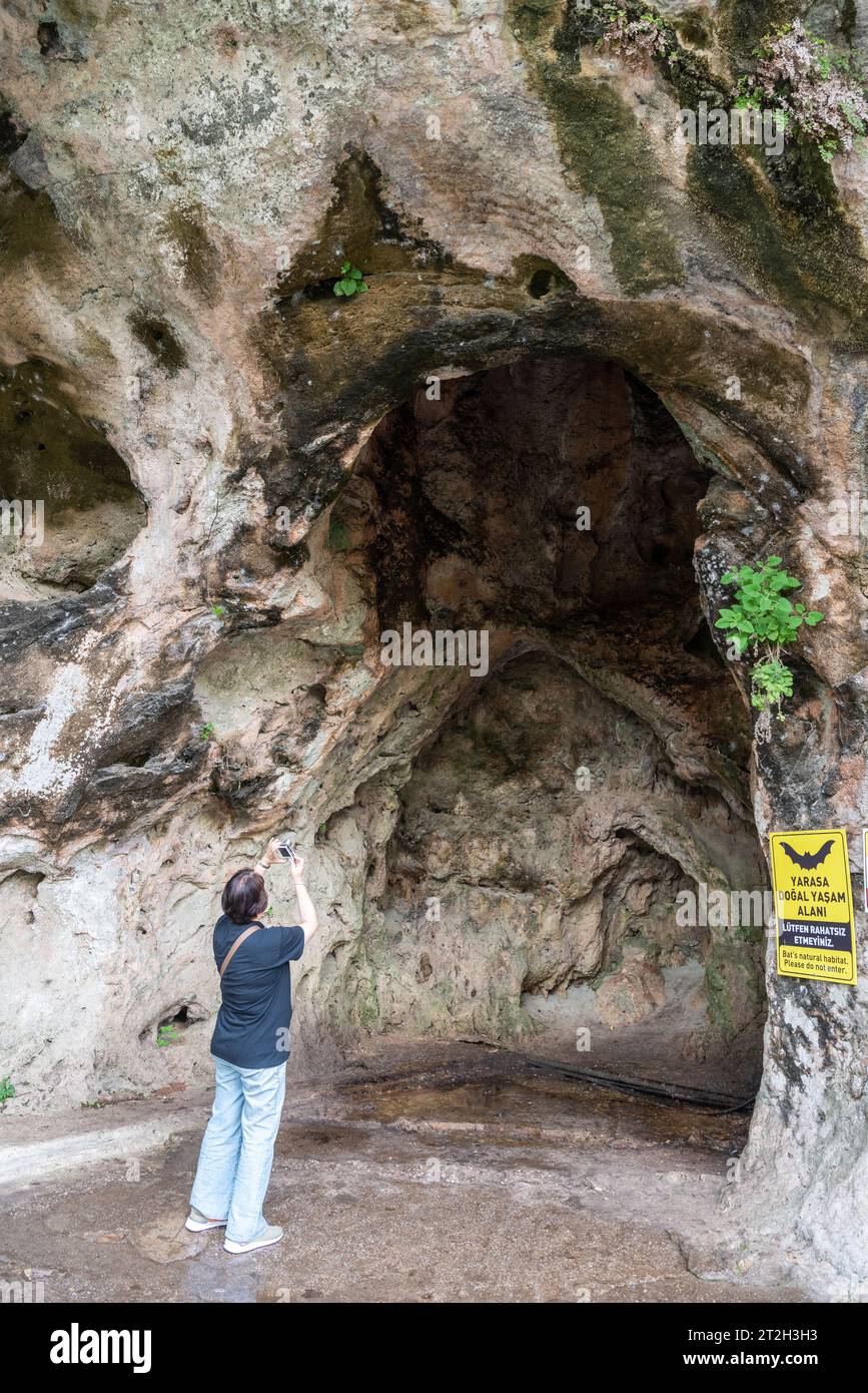 Antalya, Turkey - March 27, 2023. Karstic formations around the Upper Duden Waterfall in Antalya, Turkey. View with a ‘bat habitat’ sign and a tourist Stock Photo