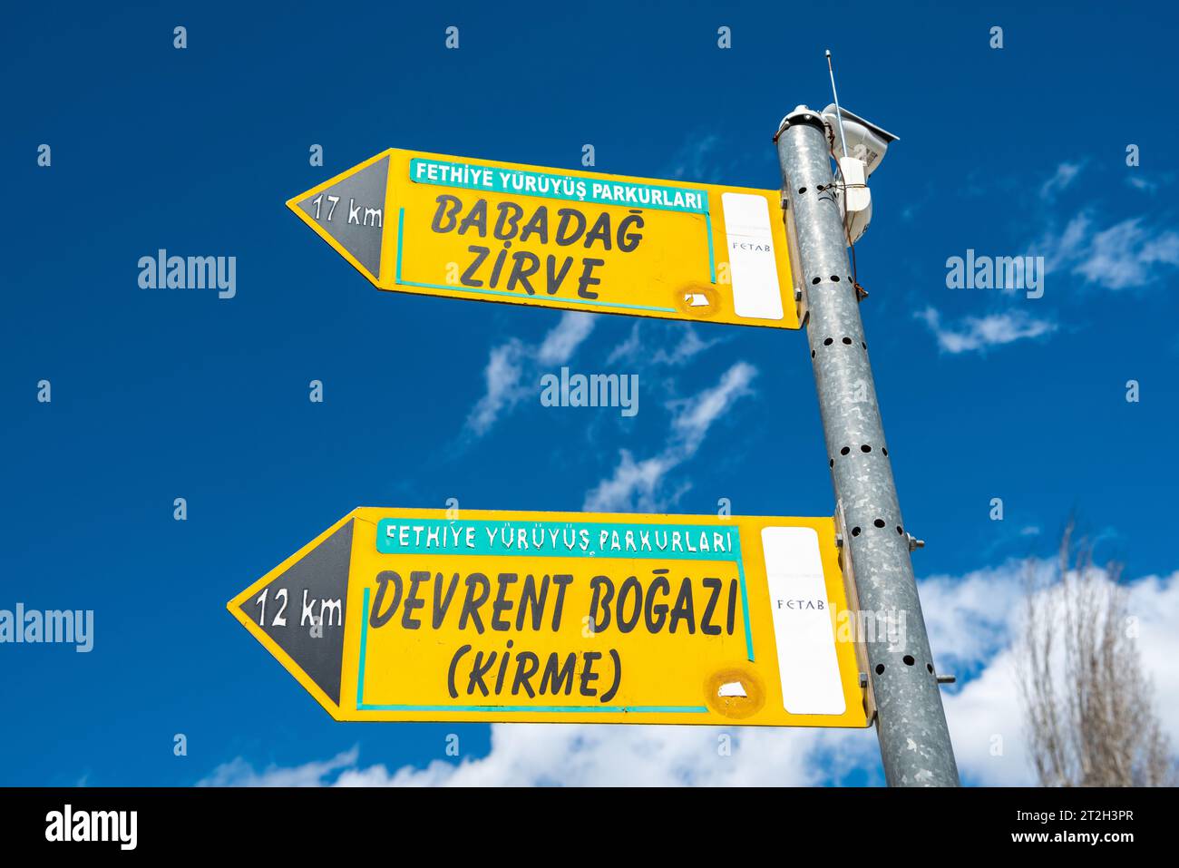 Kalkan, Antalya, Turkey – March 29, 2023. Signs showing directions and mileage to Mount Babadag summit and Devrent Bogazi at Pinara ancient site in Mu Stock Photo