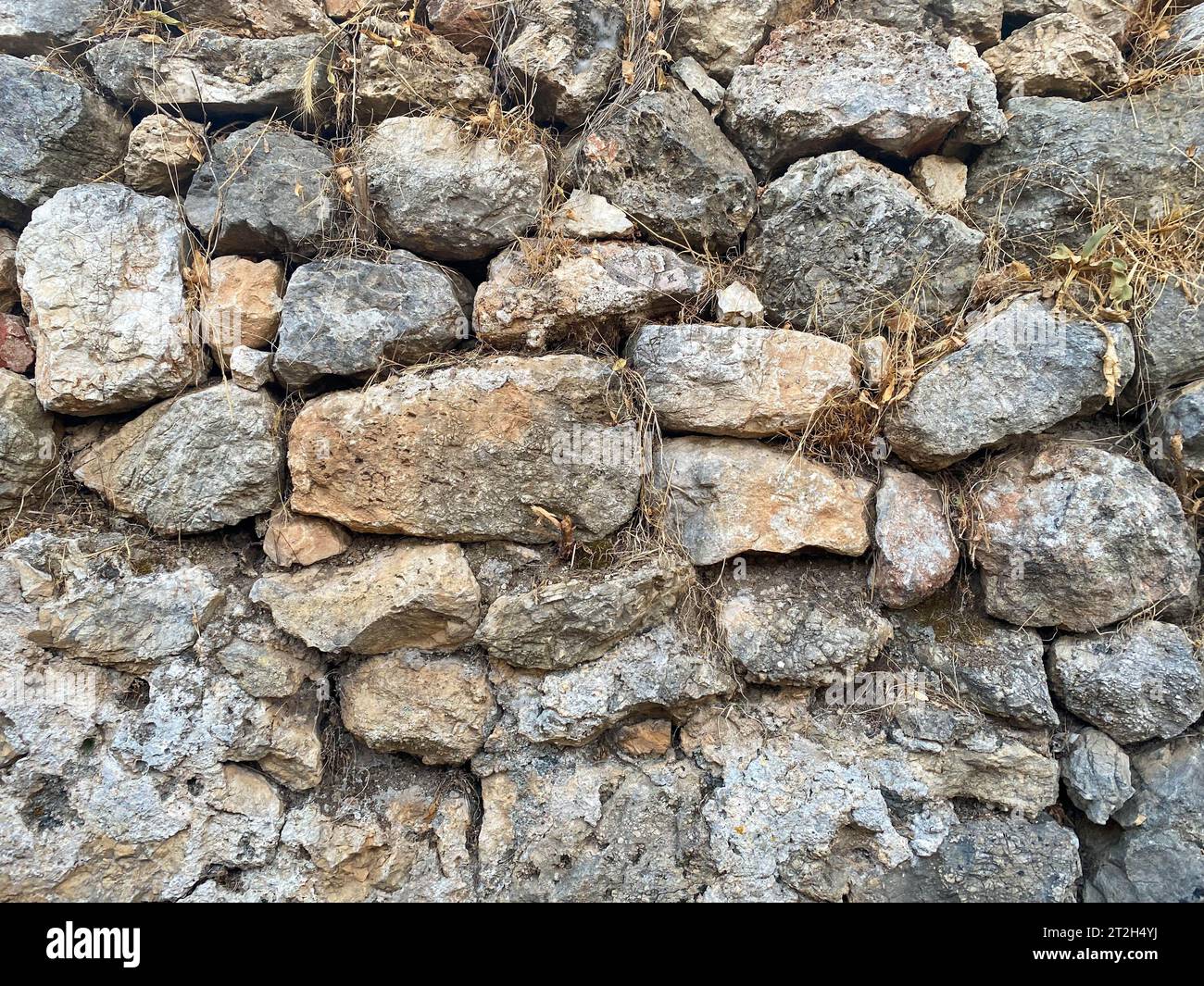 https://c8.alamy.com/comp/2T2H4YJ/background-texture-stone-wall-of-round-stones-cobblestones-bricks-natural-surface-natural-sharp-convex-rough-stone-cobblestone-with-cracks-2T2H4YJ.jpg