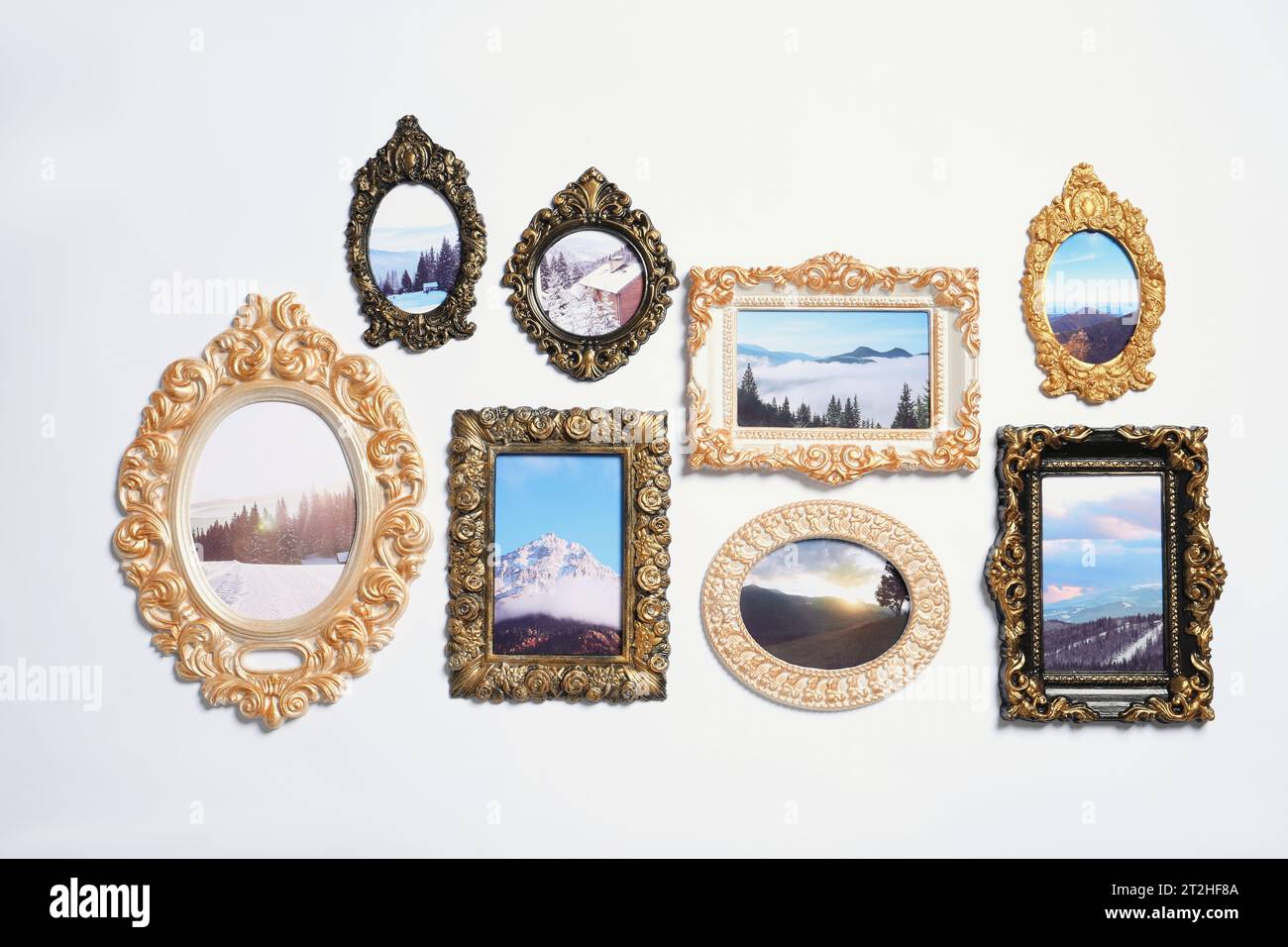 Vintage frames with photos of beautiful landscapes hanging on white