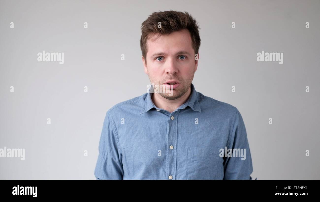 caucasian young man looks fearfully and bewilderedly into the camera Stock Photo