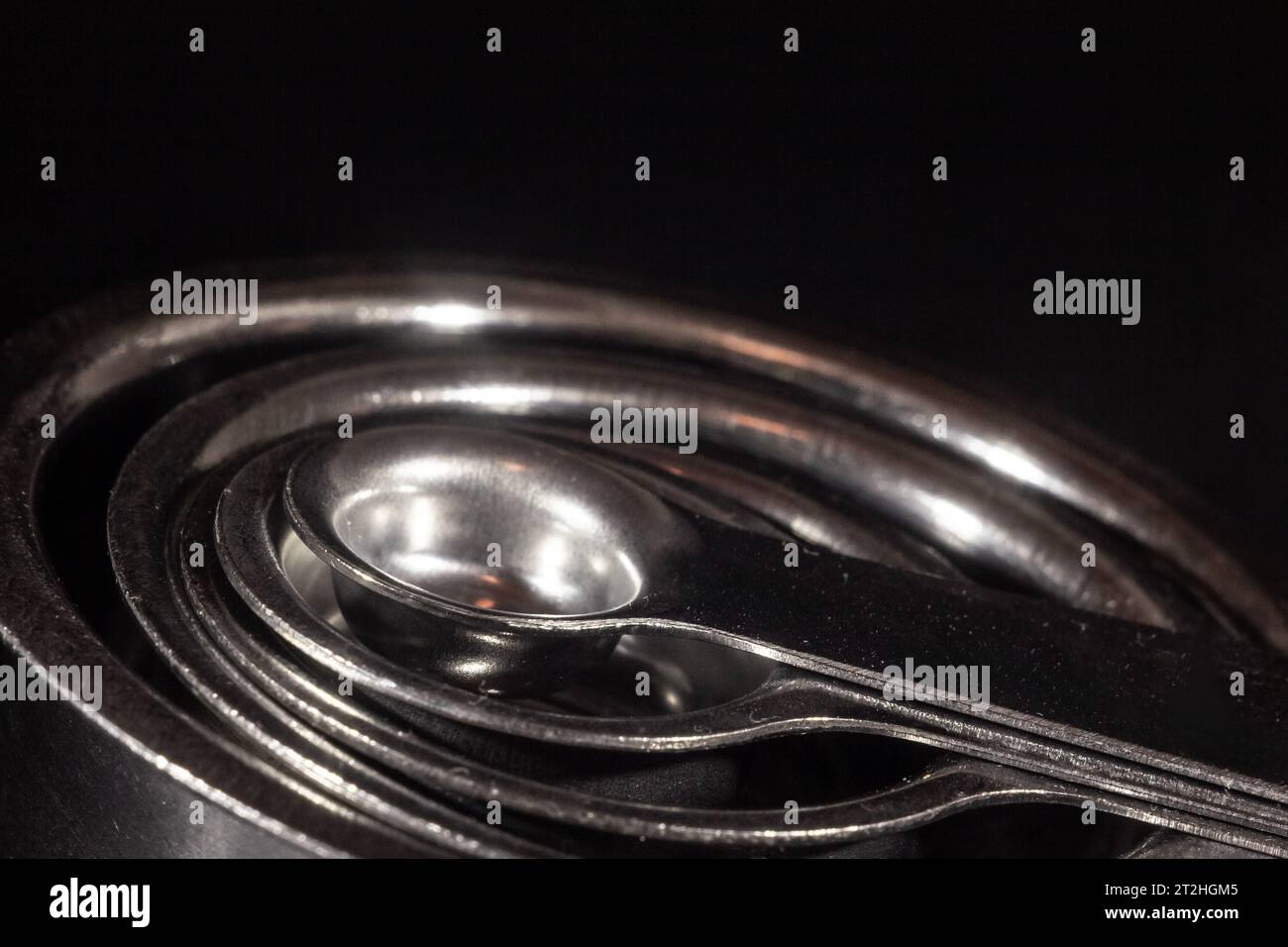 Picture of measuring teaspoons, concentrical, of various quantities, using metric system and
