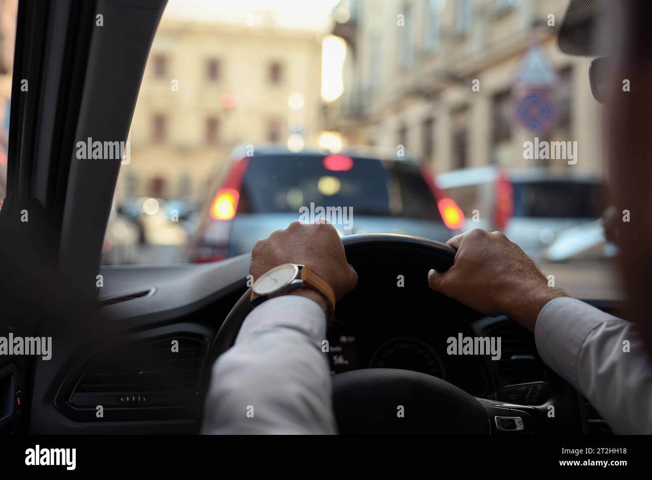 Stuck in traffic jam. Driver holding hands on steering wheel in car
