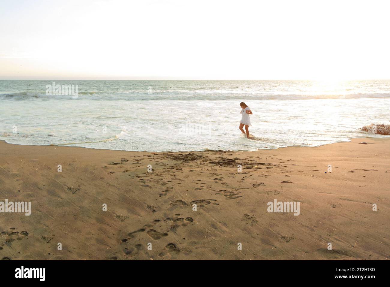 Woman walking barefoot along beach hi-res stock photography and images ...