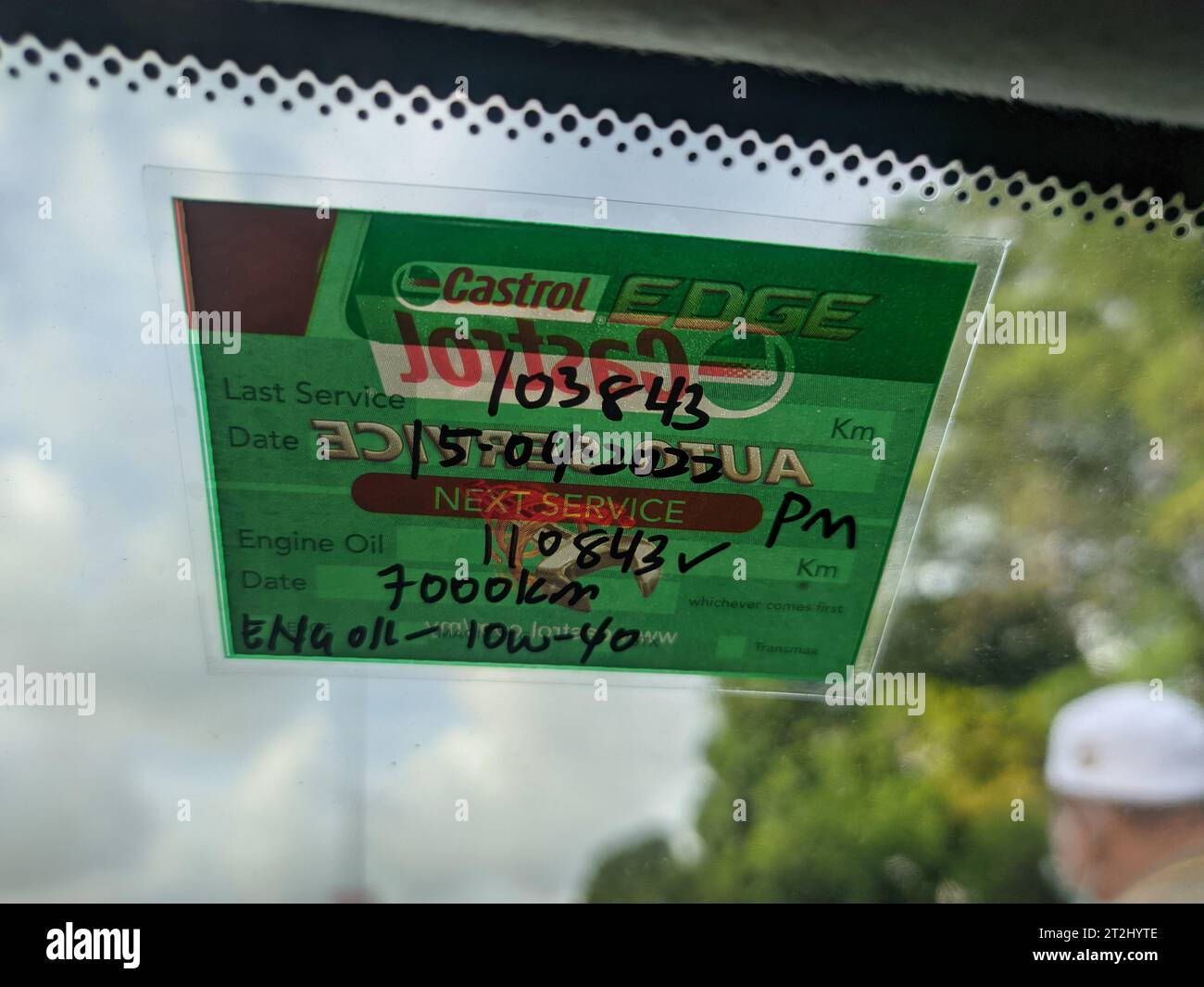 Malaysia, 15 April 2022: Next service sticker for engine oil is pasted on the inside of the car windshield. Stock Photo