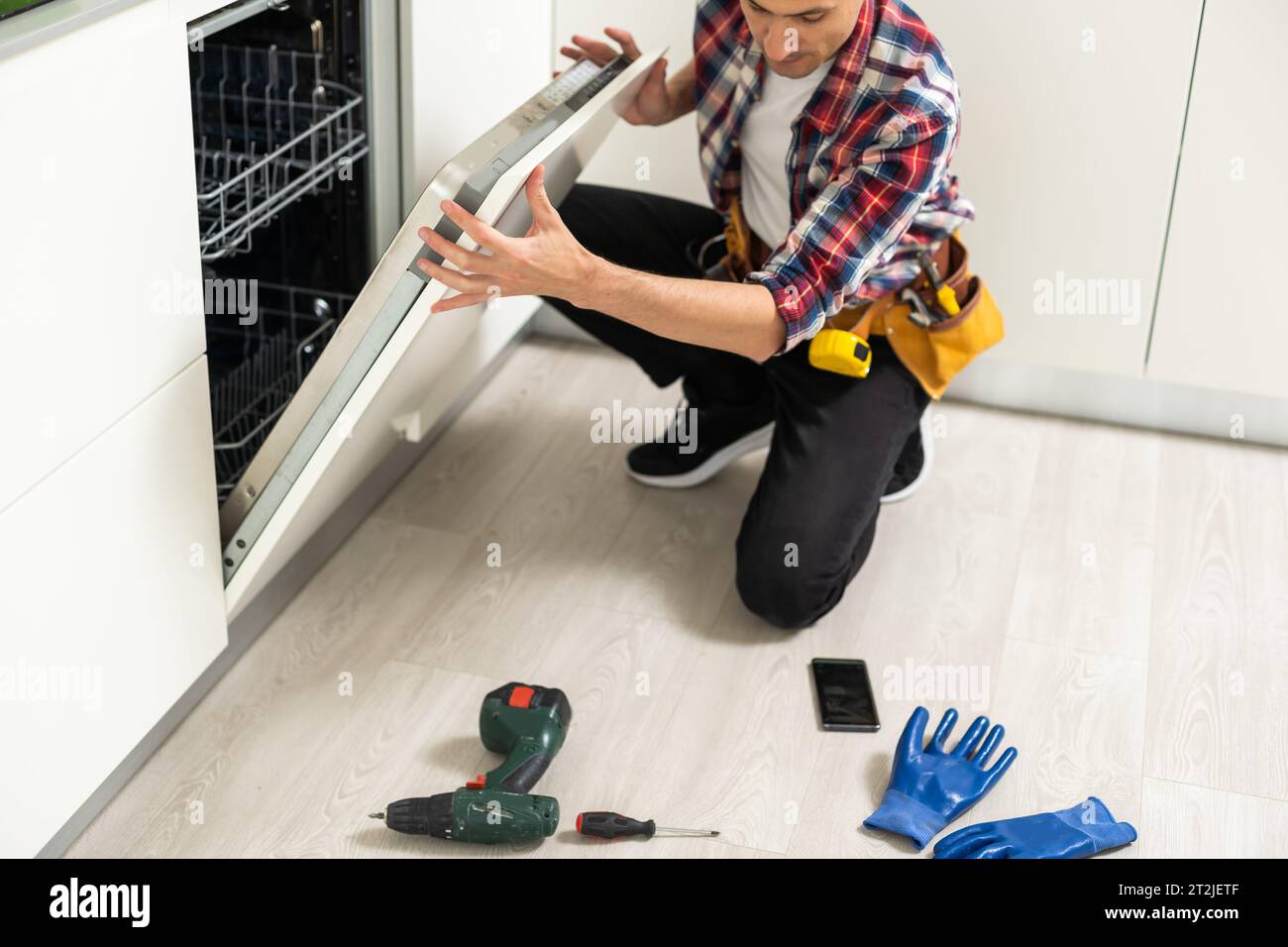 Home appliance maintenance handyman removing dirty dishwasher food