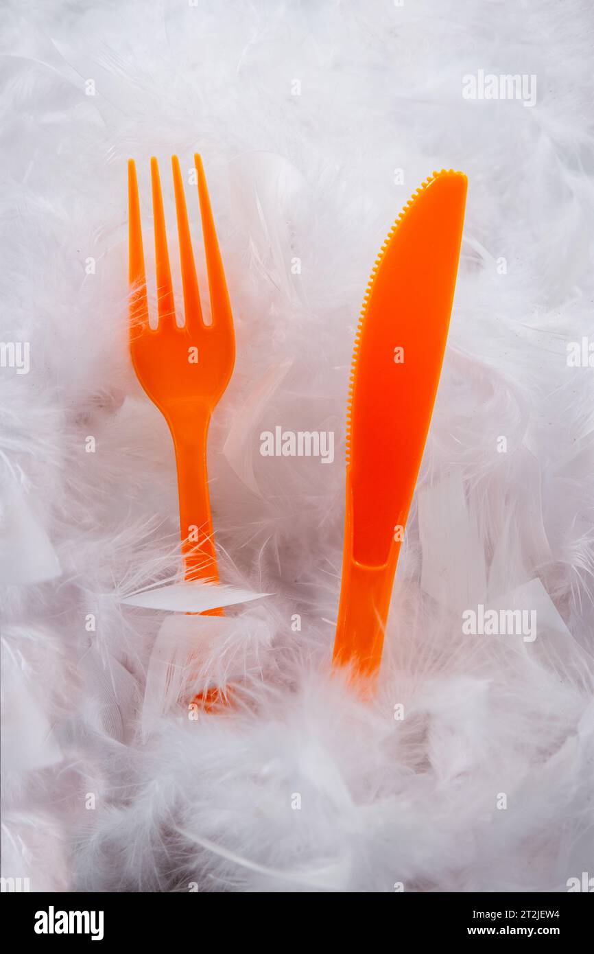 Colorful steak knives arranged on an orange background forming a page  border Stock Photo