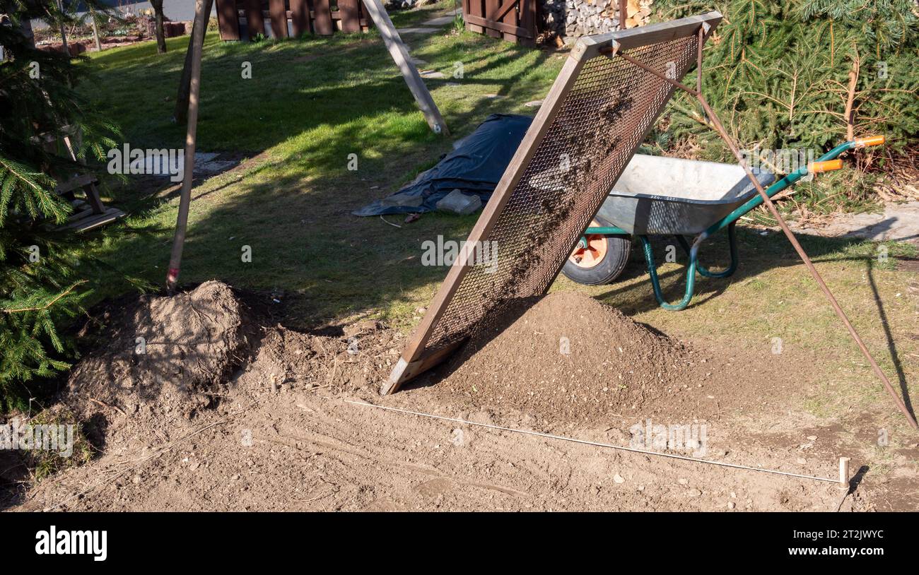 Sieve garden soil into a compost heap Stock Photo Alamy