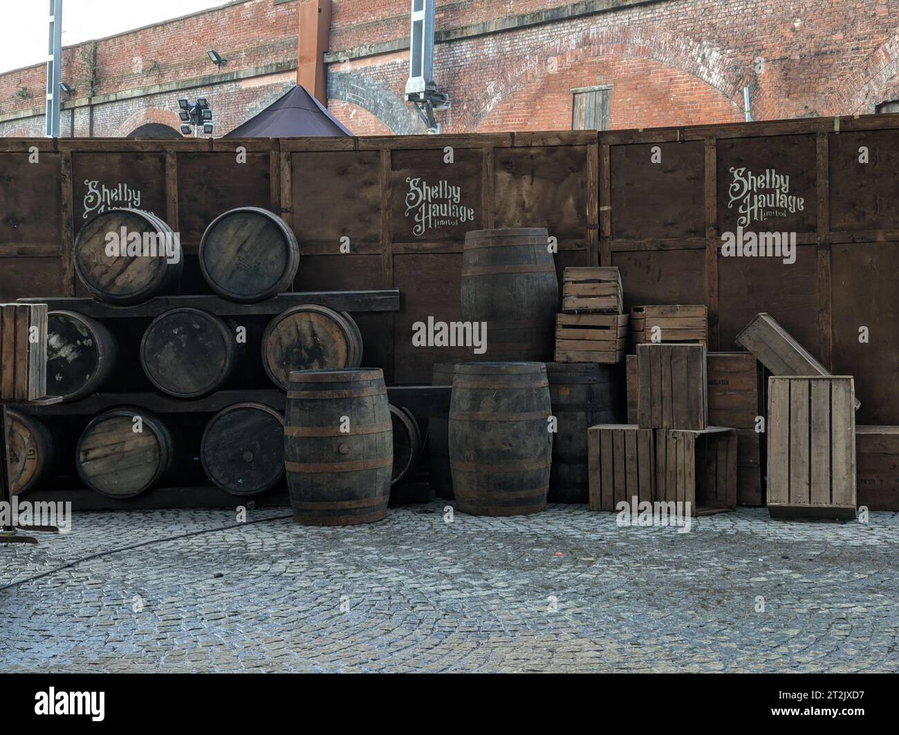 Film set for Peaky Blinders period drama at Castlefield heritage site with barrels and sign for Shelby Haulage Limited. Manchester UK. Stock Photo