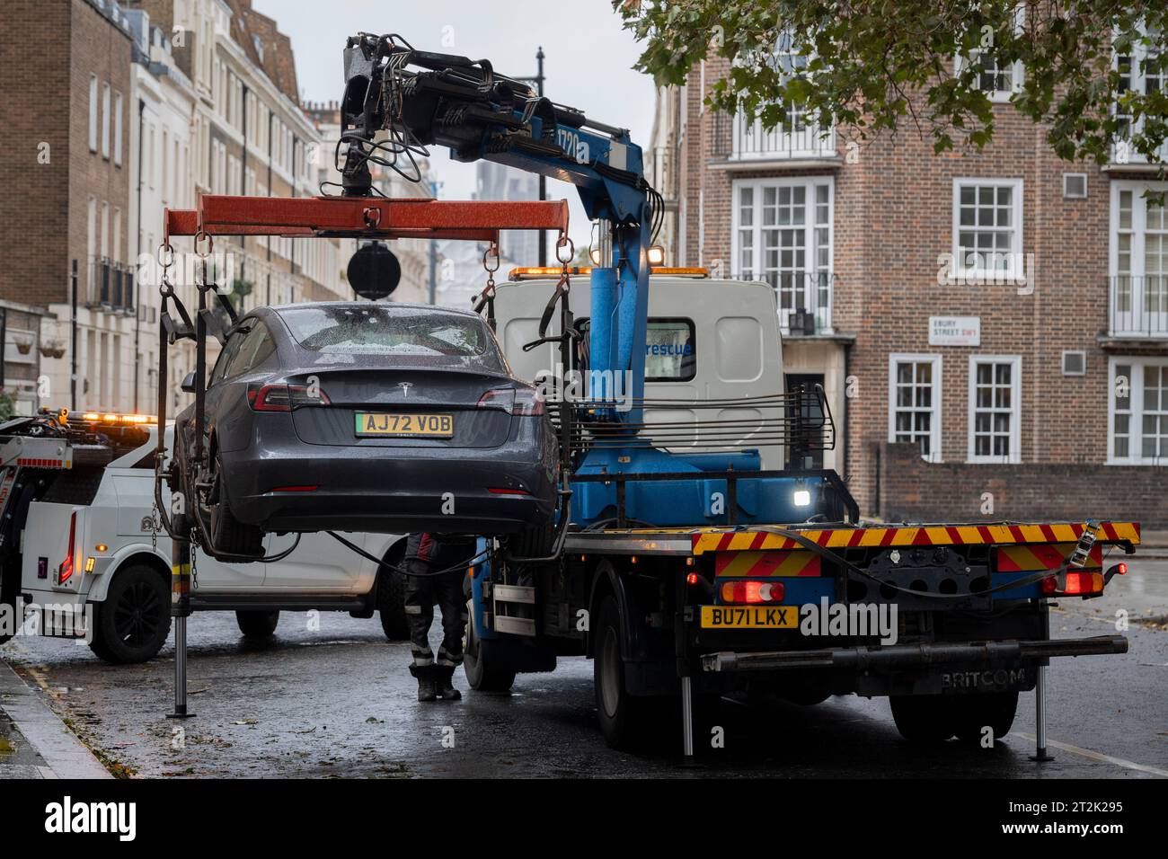 An illegally-parked and clamped Tesla car is lifted up on to a towing lorry in Victoria, on 20th October 2023, in London, England. Stock Photo