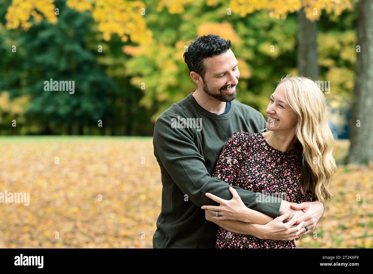 Husband and wife embracing, looking at each other smiling Stock Photo